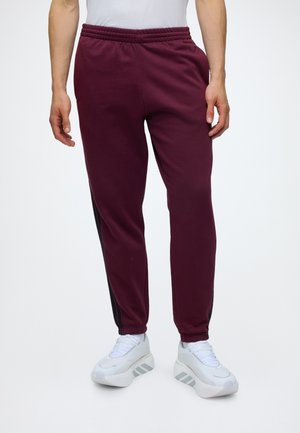 adidas Sportswear, ESSENTIALS 3 STRIPES TAPERED CUFFED PANTS - Долнище на анцуг - team maroon/black