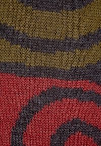 Stickad tyg med böjda ränder i mörkbrun, olivgrön och röd. Texturen är mjuk med en fin, tät väv.