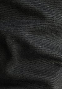 Mustat farkkukangas, jossa on teksturoidut kudokset, sisältäen vinon nauhakuvion ja kevyen kiilteen, näyttäen pehmeitä ryppyjä ja taitoksia.