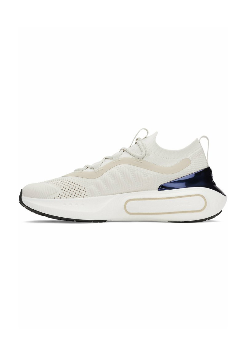White sneaker with a textured knit upper, perforated detailing, and a glossy navy accent at the heel. Features a cushioned white sole.