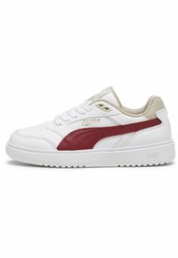 Baskets de sport avec une tige en cuir blanc, logo Puma bordeaux et accents beige. Présente un bout perforé et une semelle en caoutchouc texturé.