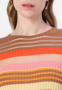 Top in maglia con strisce verticali in tonalità di marrone, arancione, rosa e crema. Morbida texture con scollatura rotonda e design a coste.