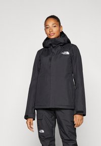 Schwarze wasserdichte Jacke mit Kapuze, Reißverschluss vorne und elastischen Bündchen. Verfügt über ein Logo auf der Brust und strapazierfähigem Material für den Außeneinsatz.