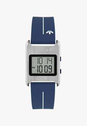 Digitālais rokas pulkstenis ar kvadrātveida metālu seju, kas rāda 22:14, uz zila silikona siksniņas ar baltu svītru un Adidas logotipu.