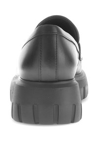 Zwarte leren schoen gezien vanaf de achterkant, met een ronde vorm en een dikke rubberen zool met getextureerde groeven voor grip.