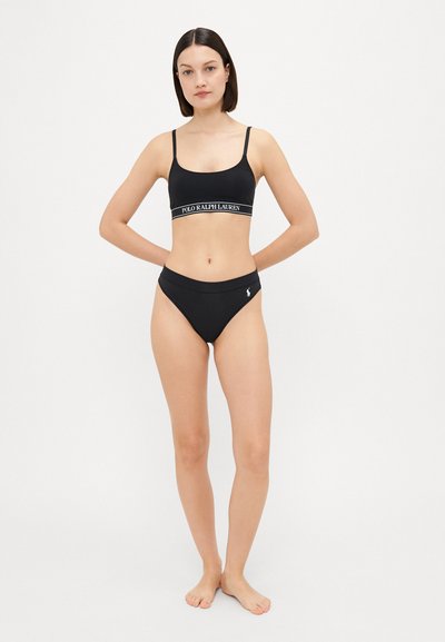 Black bikini set featuring a cropped top with adjustable straps and waistband, paired with high-cut bottoms displaying a logo accent.