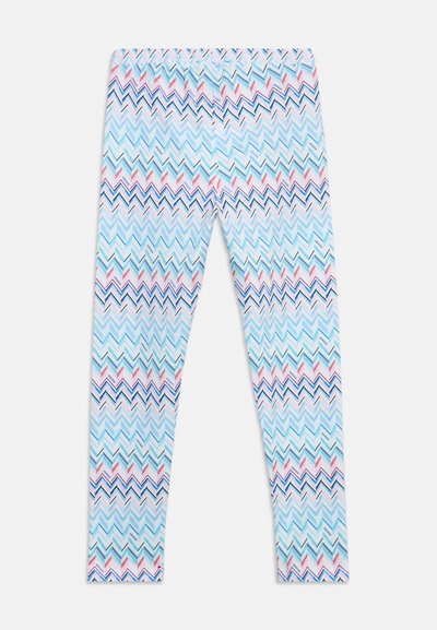 Leggings avec un motif en zigzag multicolore en bleu, rose, blanc et noir sur fond blanc, posés à plat.