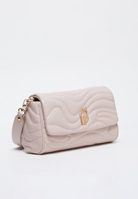 Lichtroze leren handtas met een gequilt golfpatroon, gouden accenten, een opklapbare flap en een verstelbare schouderband. Compact en rechthoekig ontwerp.