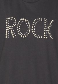 Čierne tričko s nápisom "ROCK" vytvoreným z dekoratívnych perál a kamienkov, s okrúhlym výstrihom a krátkymi rukávmi.