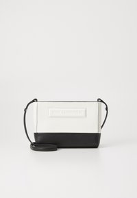 Crossbody bag featuring a white upper section with textured branding, and a solid black bottom. Adjustable strap, rectangular shape, smooth material.