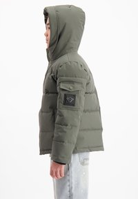 Olijfgroene pufferjack met een capuchon, voorzien van een ritssluiting aan de voorkant, horizontale stiksels en een logo-opnaad op de linkerarm.