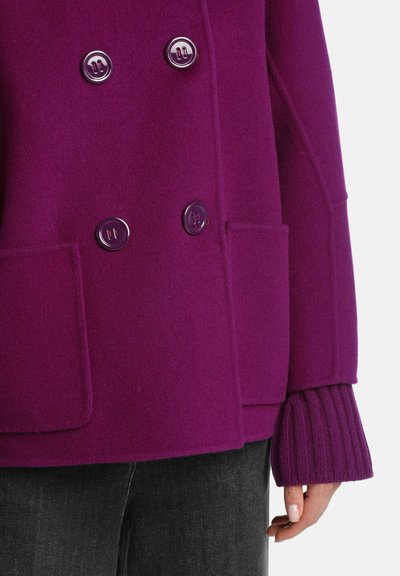 Lila doppelt knöpfbarer Wollmantel mit glänzenden Knöpfen, aufgesetzten Taschen und gerippten Bündchen. Glatte Textur und taillierte Passform.