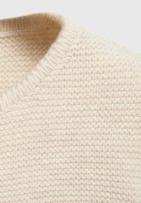 Pull in maglia beige chiaro con scollo rotondo e tessuto testurizzato con cuciture visibili. Materiale morbido e design casual.