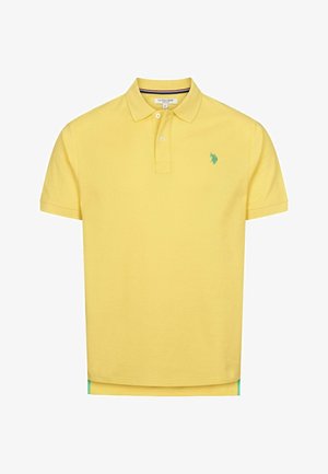 Kollane puuvillane polo särk, millel on kahe nupuga kaelus, vasakul rinnal roheline broderi logo ja allosas kontrastne sinine äär.