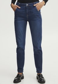 Tmavě modré slim jeans s hladkou texturou, designem s pěti kapsami, předním zapínáním na knoflík a kontrastními stehovými detaily.