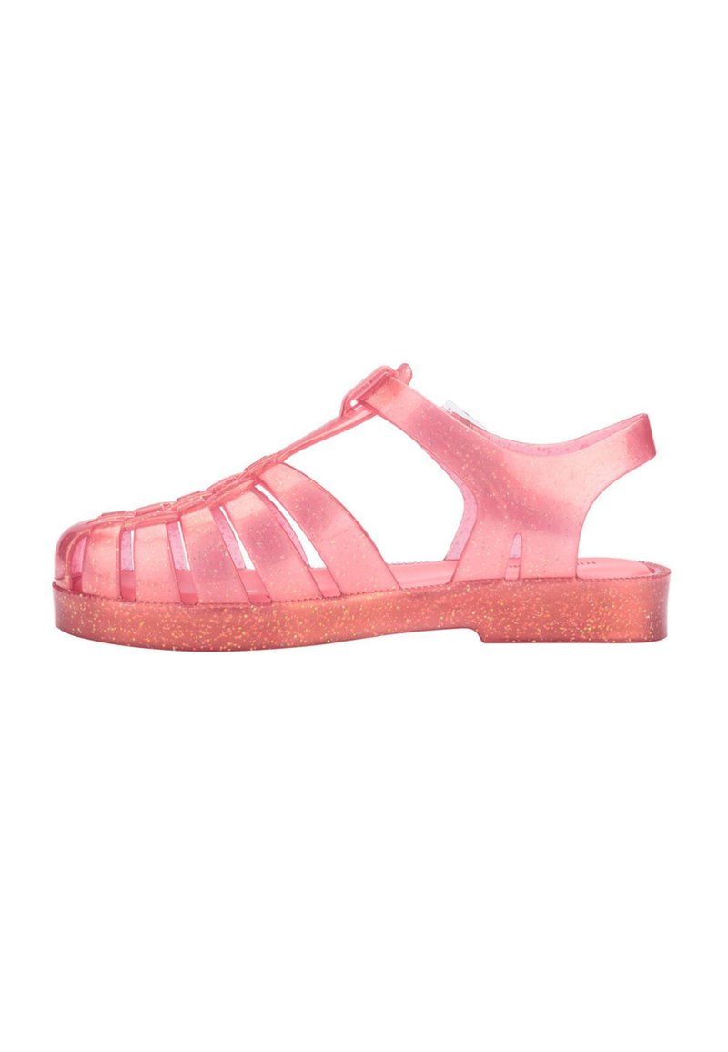 Translucent pink jelly sandal with open-toe design, featuring front straps and a textured, glittery glittery sole. Side cutouts for breathability.