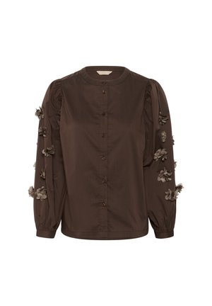 Chemise boutonnée marron avec un col rond, des manches longues bouffantes et des appliqués floraux en tissu sur les manches, fabriquée en coton lisse.