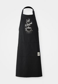 Svart bomullsforkle med en frontlomme, med hvit trykt tekst "Café Kitsuné" og en linjetegning av en kaffekopp, designet for gjestfrihet.