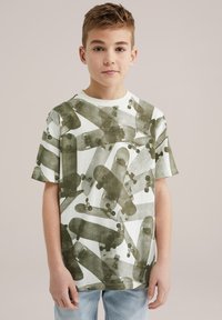 Camiseta de manga corta en crema claro con un patrón gráfico de patineta verde, con escote redondo y corte relajado.