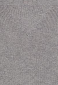 Grauer Strickpulloverstoff mit glatter Textur, der ein dezentes meliertes Muster und eine V-förmige Ausschnittdetail aufweist.