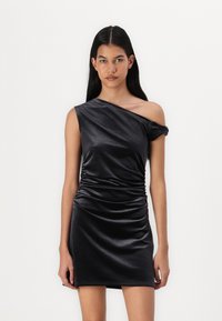 Robe noire à une épaule en tissu brillant, avec des d�étails froncés sur le côté, et une silhouette mini élégante.