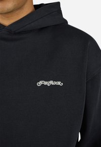 Sort hoodie lavet af bomuld, med en blød tekstur, snøre-hætte og hvid "PEGADOR" logo broderet på brystet.