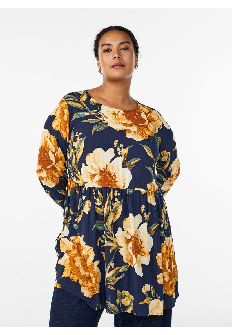 Gebloemde blouse in donker marineblauw met grote gele en oranje bloemen. Zachte stof, ronde halslijn, lange mouwen, getailleerde taille voor vorm.