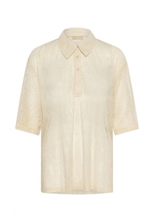 Blusa in pizzo beige a maniche corte con colletto a punta e apertura con tre bottoni, caratterizzata da un delicato motivo floreale in pizzo.