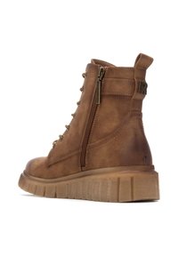 Botín de cuero marrón hasta el tobillo con cierre de cordones y cremallera lateral, parte superior texturizada, suela de goma gruesa y un detalle en relieve en la parte posterior.