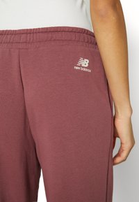 New Balance ESSENTIALS VARSITY - Tracksuit bottoms - washed burgundy