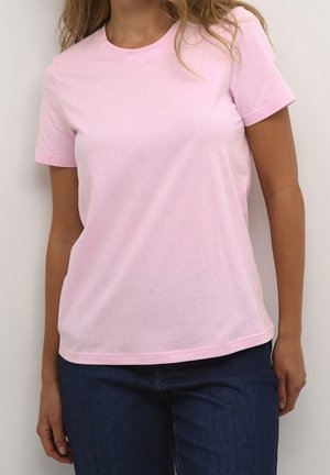 T-shirt rose à manches courtes en coton doux. Présente un col rond classique et une coupe décontractée. Associé à un jean en denim bleu.