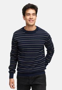 Marineblå strikket sweater med cremede vandrette striber, rund hals, og ribbede manchetter og kant. Blødt stof, normal pasform og lange ærmer.