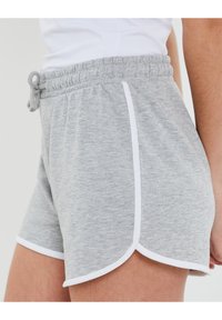 Pantaloni corti in cotone grigi con vita a coulisse, piping bianco lungo i lati e orlo curvo. Tessuto morbido con una vestibilità comoda.