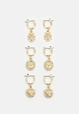 Conjunto de três pares de brincos de argola em tom dourado, apresentando pendentes de coruja, leão e borboleta, adornados com strass transparentes.