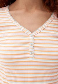 Gestreiftes Oberteil mit horizontalen Linien in verschiedenen Orangetönen, Rosa und Weiß. Es hat einen V-Ausschnitt, eine Spitzenverzierung und drei Knöpfe auf der Vorderseite.