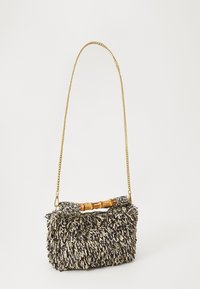Borsa nera e crema in tessuto con design a frange, manico in bambù e tracolla in oro. Forma compatta, adatta per un uso casual.