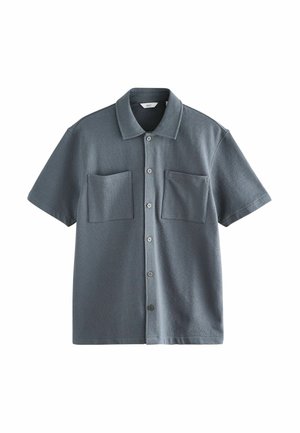 Chemise gris foncé à manches courtes avec boutons, deux poches poitrine et col pointu, étalée à plat sur fond blanc.