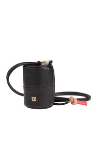 Bolso cruzado redondo de cuero negro con un logo dorado, correa delgada y un detalle de cierre con cordón rojo y beige. Textura suave.