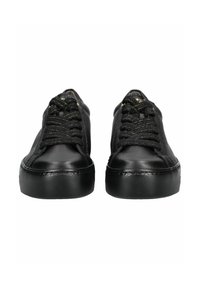 Pár černých kožených tenisek s tlustými gumovými podrážkami a černými tkaničkami, pohled zepředu na bílém pozadí.