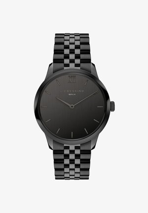 Zwarte horloge met een slank, rond kast, minimalistische wijzerplaat, zilveren uuraanduidingen en een metalen schakelband. Getextureerde gradient wijzerplaat met merklogotipo.