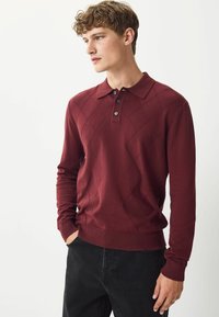 Bordo ilgomis rankovėmis polo megztinis su deimanto raštu, dviem mygtukais per krūtinę, sutrauktais rankogaliais ir apatine dalimi, minkšta tekstūra, derinamas su juodais džinsais.