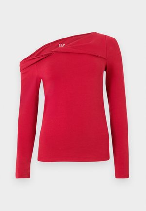 Haut rouge à manches longues avec un col décolleté sur les épaules et un détail de tissu torsadé près de l'encolure, fabriqué en matière douce et extensible.