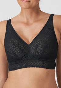 Bralette in pizzo nero con scollatura a V, decorato con intricati motivi floreali, dotato di un ampio elastico e di un tessuto morbido e testurizzato.