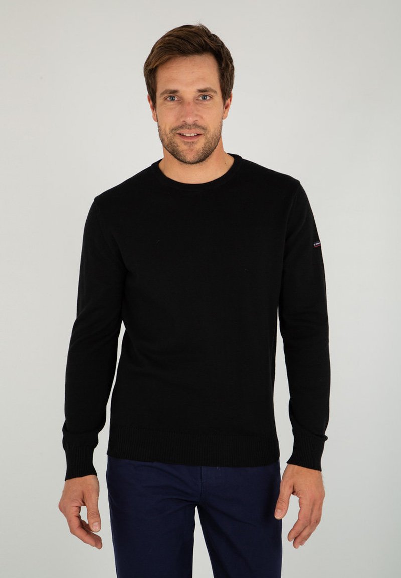 Maglione nero a maniche lunghe con collo rotondo, in maglia, con polsini e orlo a coste; presenta un piccolo logo sulla manica sinistra.