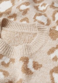 Sweter dzianinowy o miękkiej, beżowej fakturze z wzorem w panterę w jasnobrązowym i białym kolorze. Żebrowany okrągły dekolt dodaje szczegółu.