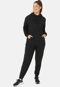 Black sweatshirt and jogger set, cotton blend, kangaroo pocket, adjustable hood, cuffed sleeves and ankles. Features subtle logo detail.