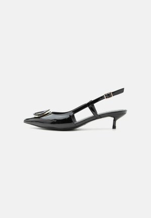 Sort laklæder slingback-sko med kitten-hæl, spids tå, udskårne sider, spænde rem og cirkulært metal detalje på tåen.