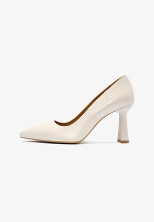 Zapato de tacón alto de cuero blanco con punta puntiaguda, tacón ancho acampanado único y acabado suave.