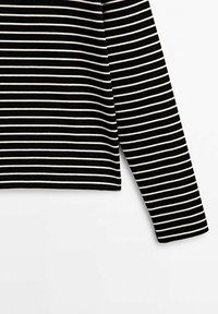 Haut à manches longues noir avec de fines rayures blanches horizontales uniformément espacées, présenté de profil sur un fond blanc uni.