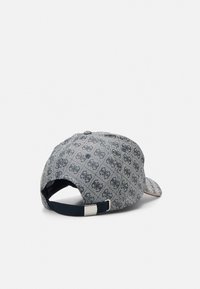 Casquette en tissu bleu texturé avec un motif répétitif, visière courbée et une sangle ajustable à l'arrière avec une boucle en argent.